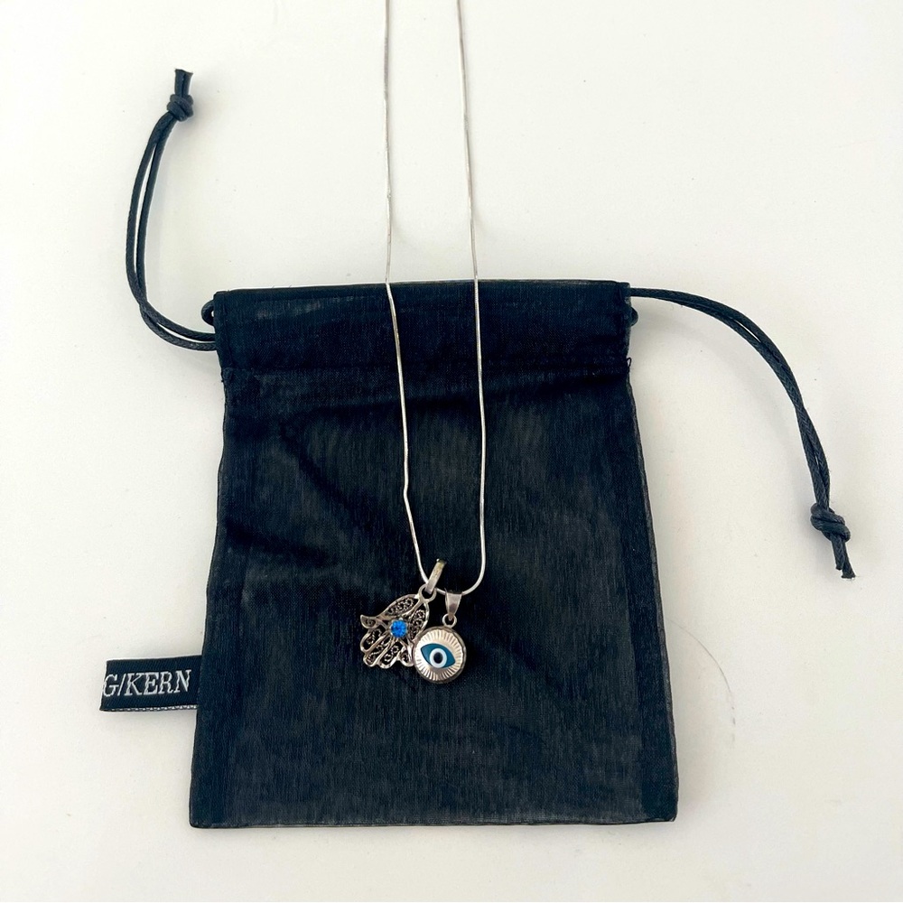 Silver necklace with lucky Hamsa 🪬 charm and all seeing eye.
